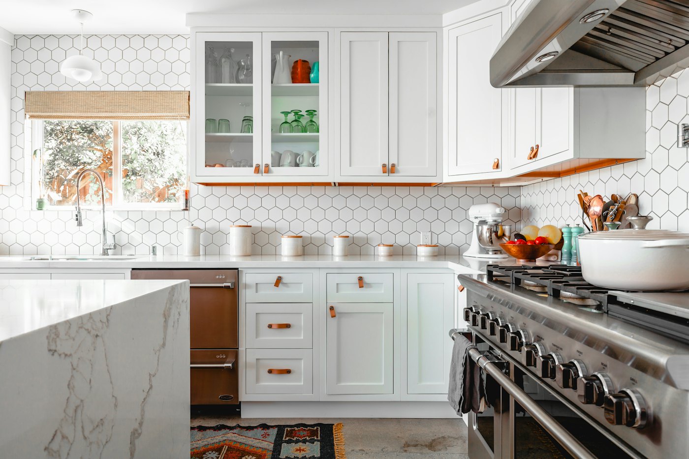 White shaker kitchen with hexagonal tiles and a waterfall marble island