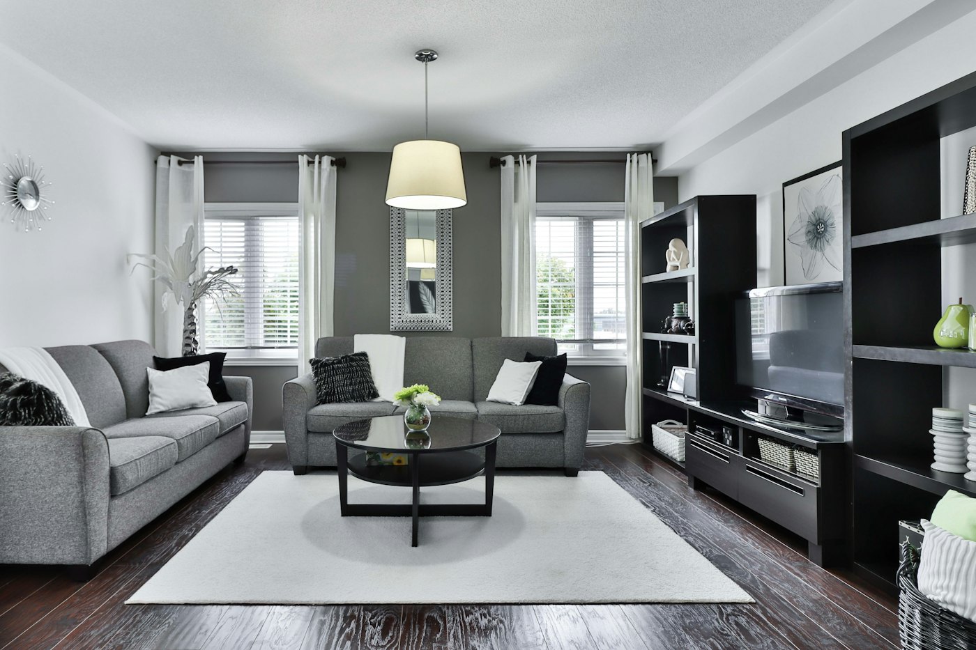 Grey living room with a built-in dark TV wall unit and round coffee table