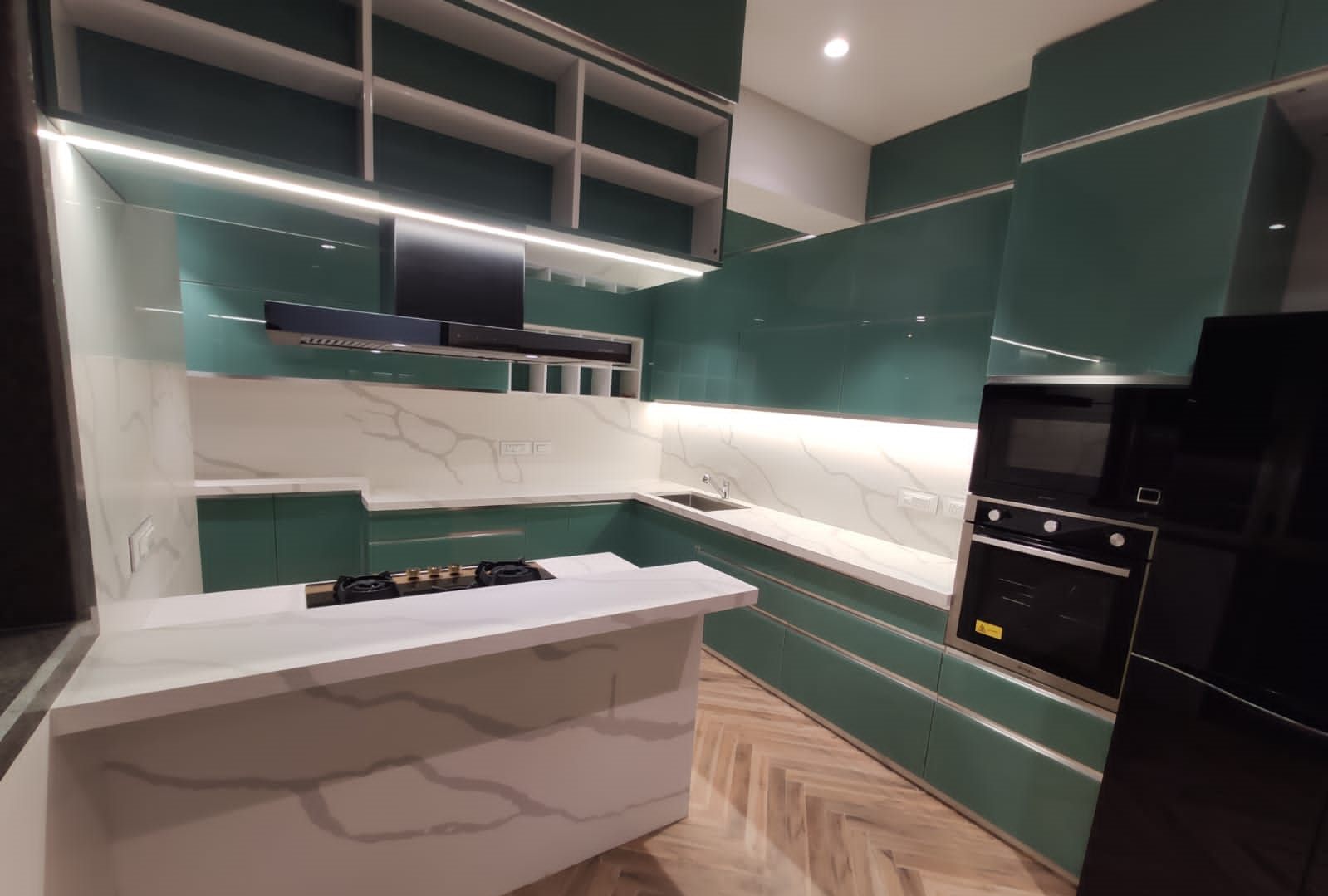 Emerald back-painted glass kitchen with a marble-look island, backsplash and built-in oven