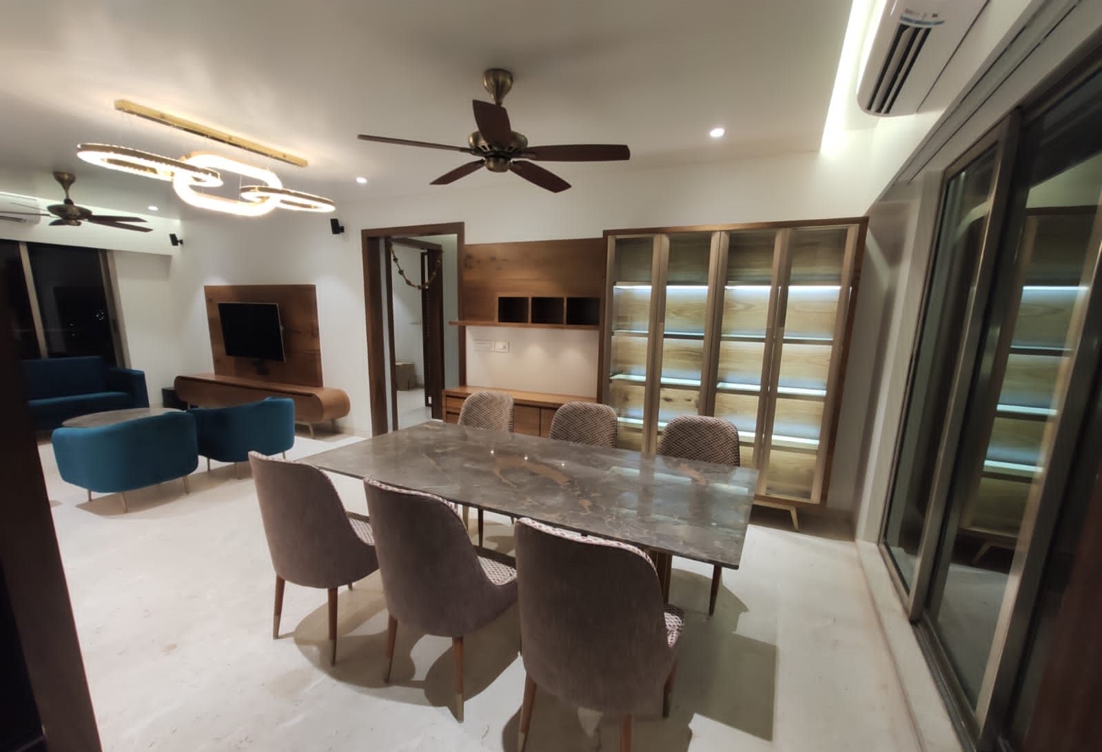 Dining table with walnut display cabinets and the living room beyond
