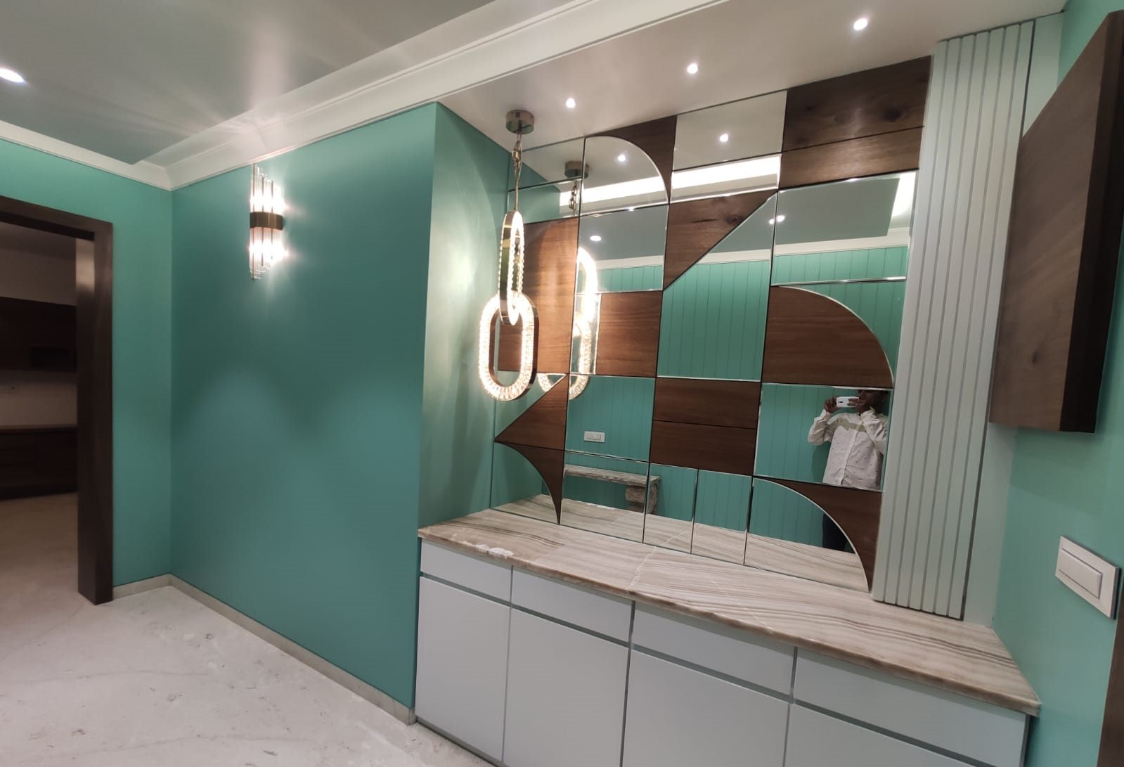 Foyer with teal walls, shoe cabinet and statement pendant
